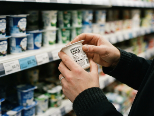 Checking a food label to choose keto friendly probiotic foods at the supermarket.